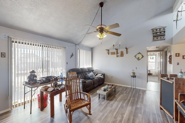 living room with hardwood / wood-style floors, vaulted ceiling, a textured ceiling, and ceiling fan