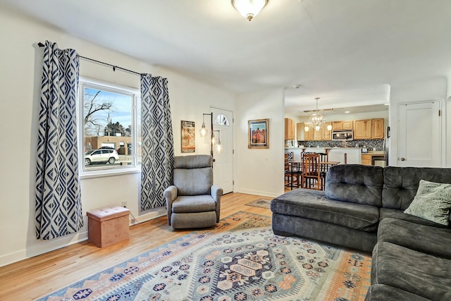 living room with a notable chandelier and light hardwood / wood-style flooring