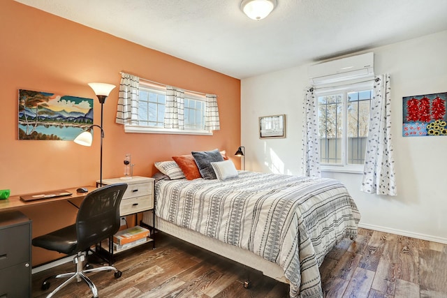 bedroom with dark wood-type flooring and a wall mounted AC