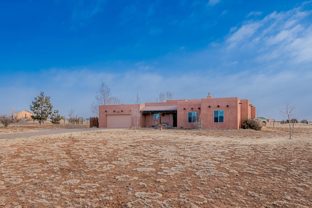 pueblo-style house featuring a garage