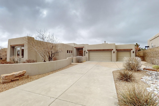 pueblo revival-style home with a garage