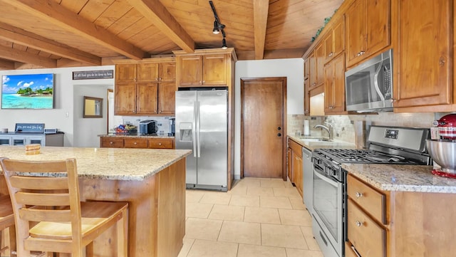 kitchen with a breakfast bar, sink, light stone counters, wooden ceiling, and stainless steel appliances