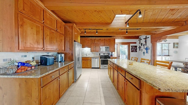 kitchen featuring a skylight, a kitchen bar, a large island, stainless steel appliances, and wooden ceiling