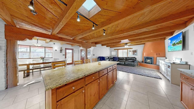 kitchen featuring a healthy amount of sunlight, a center island, wooden ceiling, and a skylight