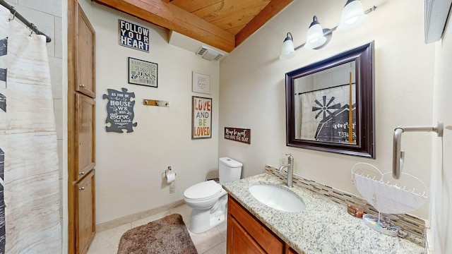 bathroom featuring tile patterned flooring, vanity, beamed ceiling, and toilet