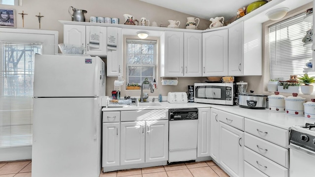 kitchen featuring light tile patterned flooring, white appliances, sink, and white cabinets