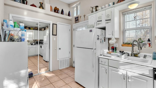 kitchen featuring sink, white cabinets, and white refrigerator