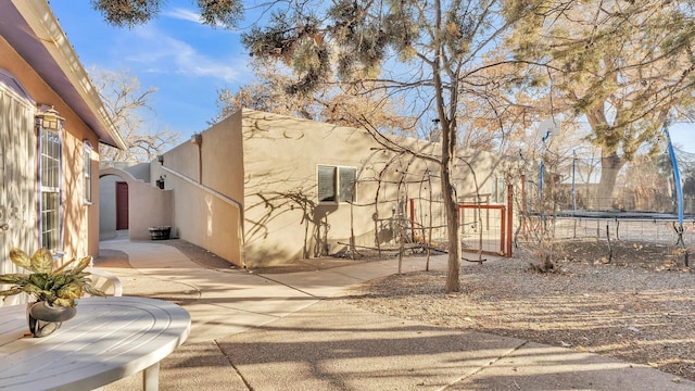 exterior space with a trampoline and a patio area