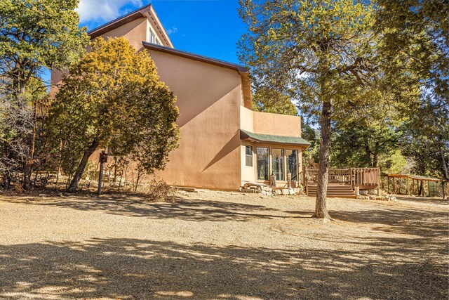 view of side of home featuring a wooden deck