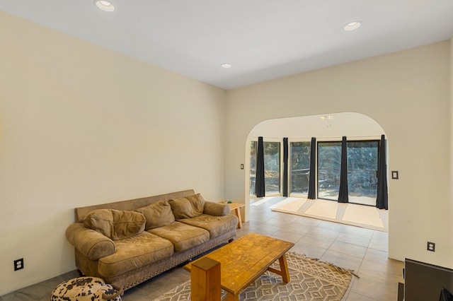 living area with arched walkways, light tile patterned floors, and recessed lighting