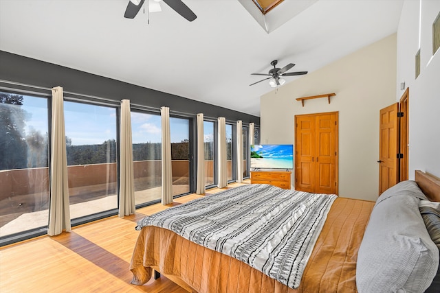 bedroom with access to exterior, high vaulted ceiling, light wood finished floors, and a ceiling fan