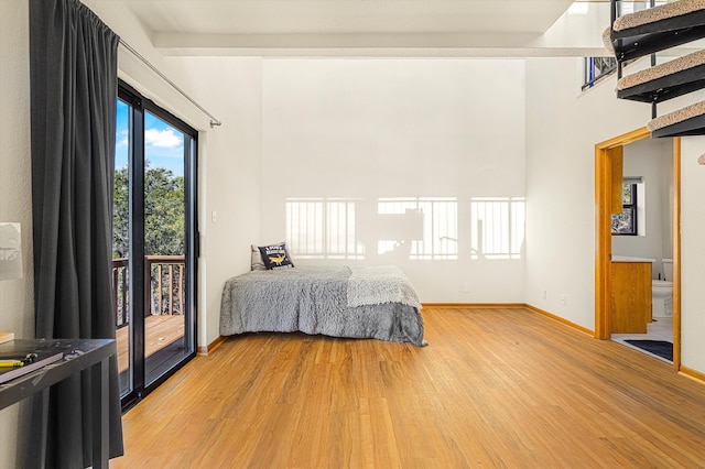 bedroom with access to exterior, baseboards, and wood finished floors