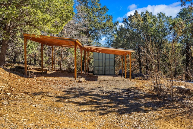 view of yard with a storage shed, an outbuilding, and a detached carport