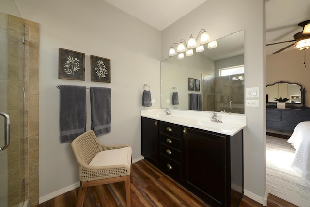 bathroom with ceiling fan, wood-type flooring, a shower with door, and vanity