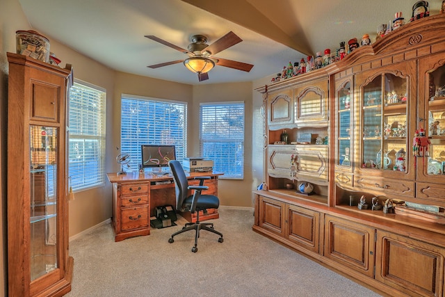 carpeted office space with plenty of natural light and ceiling fan