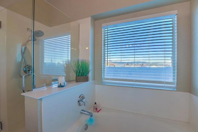 bathroom featuring plus walk in shower and a healthy amount of sunlight