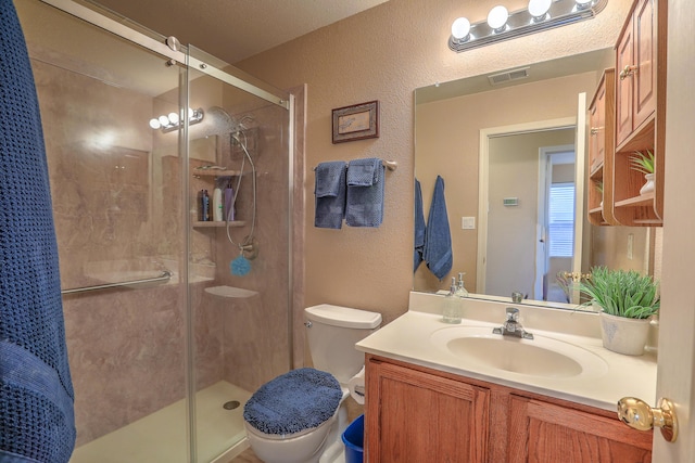 bathroom with vanity, toilet, and a shower with door