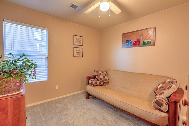 living room with plenty of natural light, light colored carpet, and ceiling fan