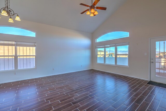 interior space with ceiling fan with notable chandelier and high vaulted ceiling