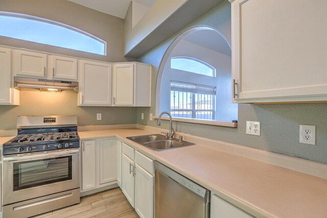 kitchen featuring plenty of natural light, stainless steel appliances, sink, and white cabinets