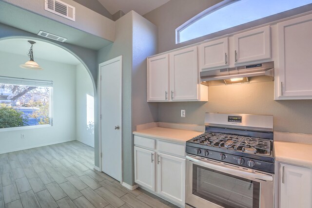 kitchen with pendant lighting, stainless steel gas range oven, and white cabinets