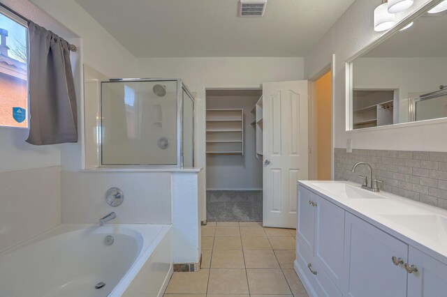 bathroom featuring vanity, backsplash, tile patterned floors, and plus walk in shower