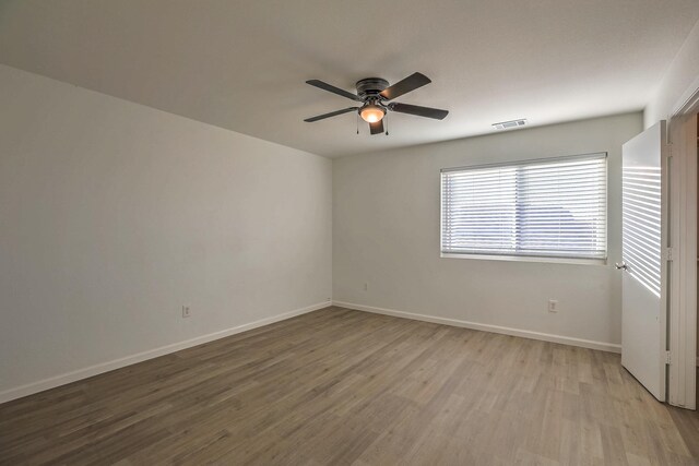 empty room with ceiling fan and light hardwood / wood-style flooring