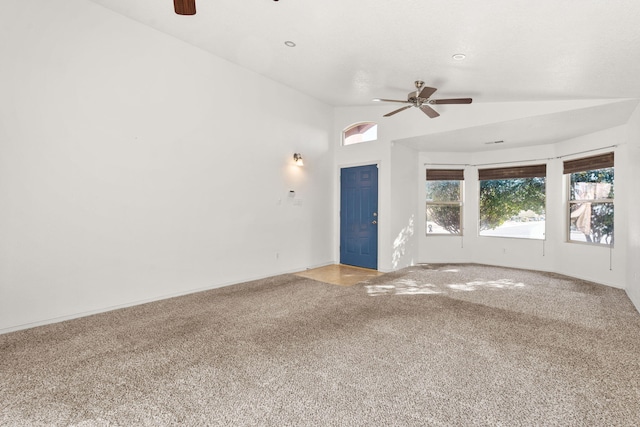 unfurnished living room with vaulted ceiling, carpet flooring, and ceiling fan