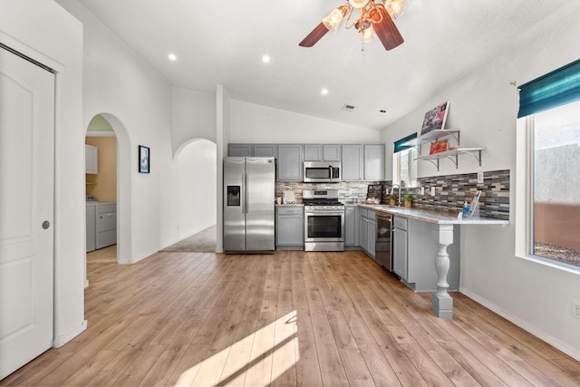 kitchen with stainless steel appliances, light countertops, gray cabinets, open shelves, and tasteful backsplash