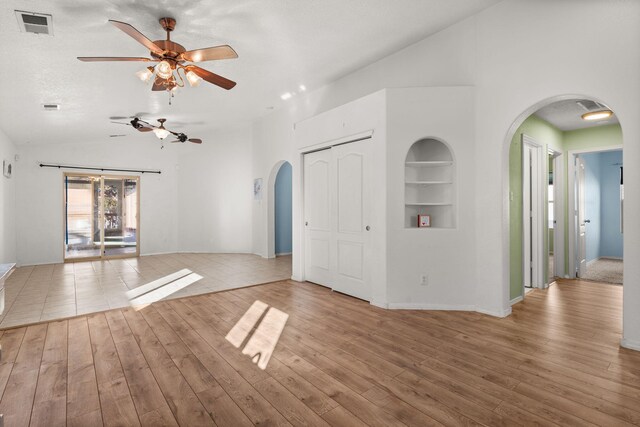 unfurnished living room featuring ceiling fan, lofted ceiling, and carpet