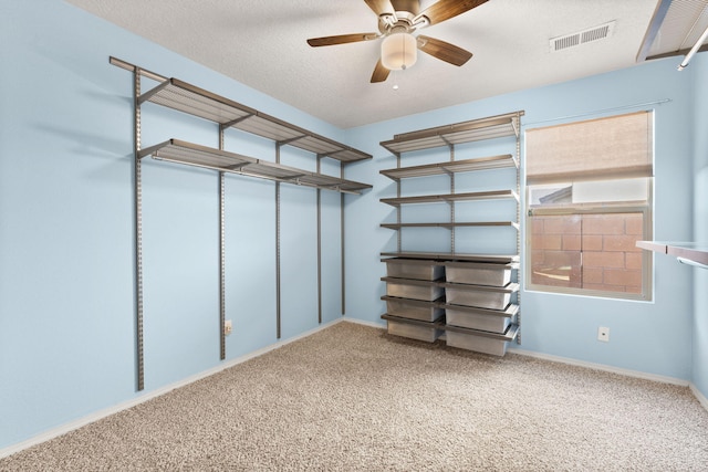 walk in closet with carpet flooring and ceiling fan