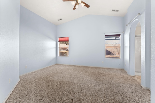 spare room featuring light carpet, ceiling fan, visible vents, and vaulted ceiling