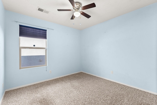 carpeted spare room with a ceiling fan, visible vents, and baseboards