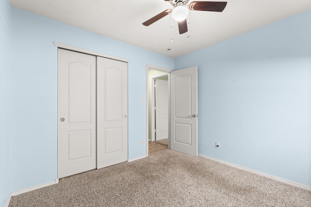 unfurnished bedroom with ceiling fan, baseboards, a closet, and light colored carpet