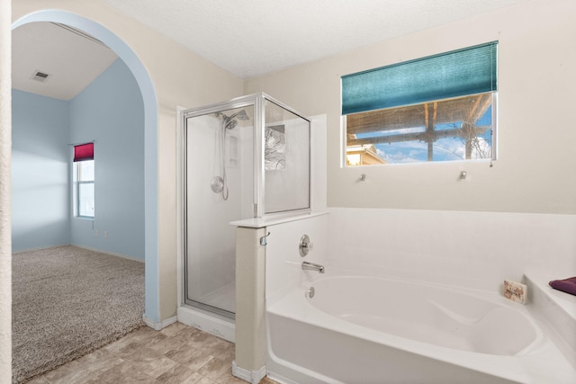 full bath featuring a stall shower, visible vents, a garden tub, and a textured ceiling