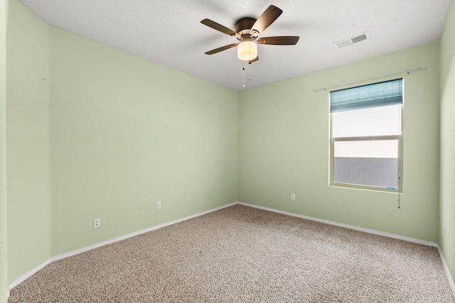 empty room featuring a ceiling fan, baseboards, visible vents, and carpet flooring