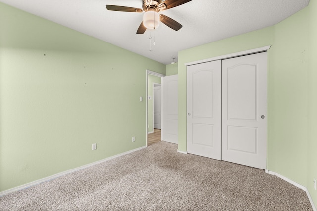 unfurnished bedroom featuring a ceiling fan, a closet, carpet flooring, and baseboards