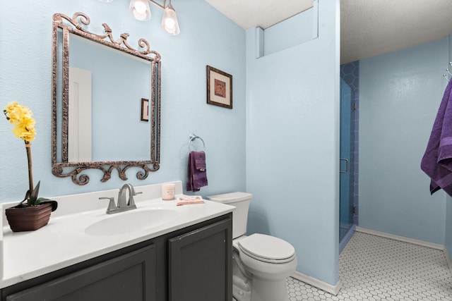 bathroom featuring toilet, a shower stall, baseboards, and vanity