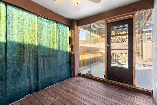 unfurnished sunroom with plenty of natural light and a ceiling fan