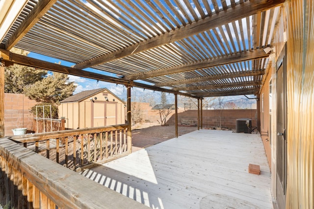 wooden terrace featuring a shed, a fenced backyard, an outdoor structure, and cooling unit