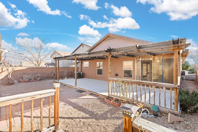 back of property featuring a deck, fence, and stucco siding