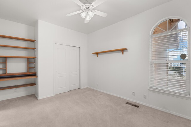 unfurnished bedroom with baseboards, visible vents, a ceiling fan, carpet floors, and a closet