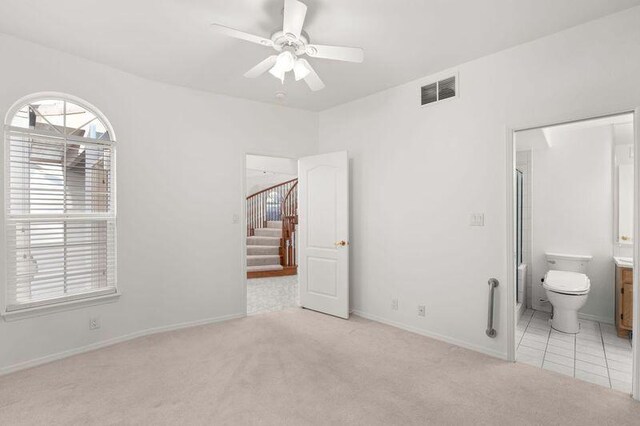 unfurnished bedroom featuring a closet, visible vents, a ceiling fan, light carpet, and baseboards