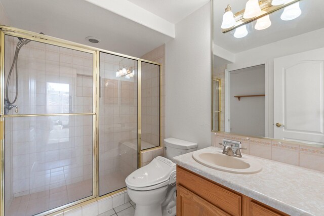 bathroom featuring toilet, a stall shower, tile patterned floors, and vanity