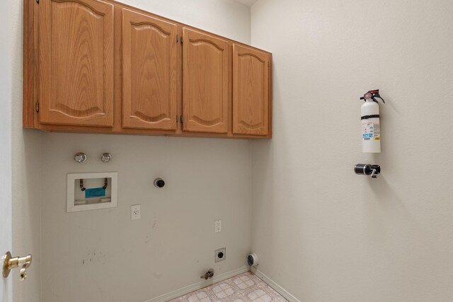 clothes washing area featuring gas dryer hookup, hookup for an electric dryer, washer hookup, baseboards, and cabinet space