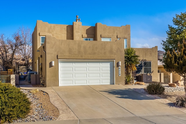 pueblo-style home featuring a garage