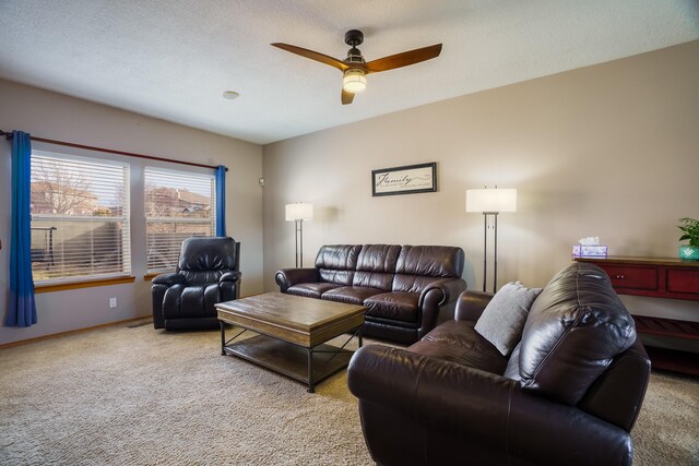 carpeted living room featuring a textured ceiling and ceiling fan