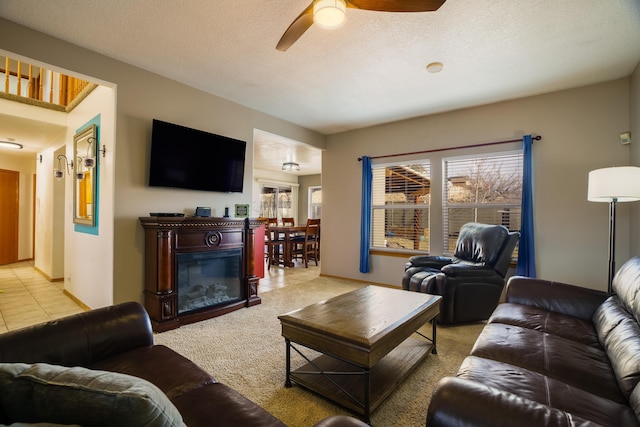 carpeted living room featuring ceiling fan and a textured ceiling