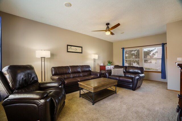 living room with light colored carpet, a textured ceiling, and ceiling fan