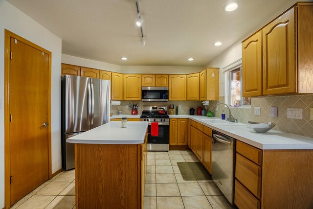 kitchen with light tile patterned flooring, appliances with stainless steel finishes, tasteful backsplash, sink, and a center island